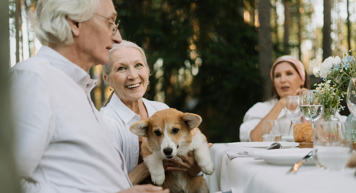 Starija osoba u narucju drzi psa